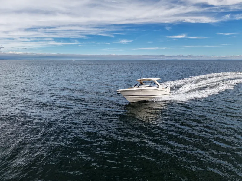 Slide: The Image of A Scout 288 Dorado boat speeds across the open sea under a blue sky. - 9