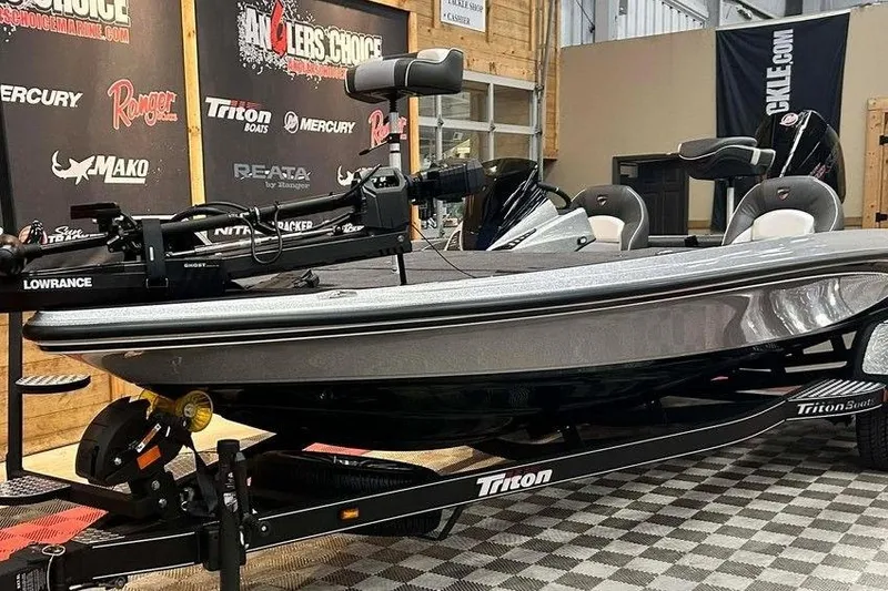 Slide: The Image of 2026 Triton 21XP Patriot boat displayed indoors on a trailer. - 11