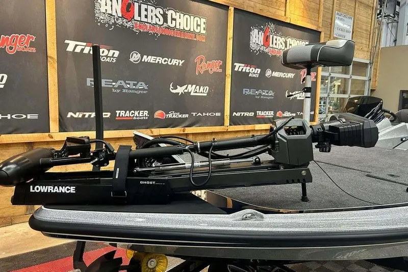 Slide: The Image of Triton 21XP Patriot 2026 boat with Lowrance Ghost trolling motor in showroom. - 12