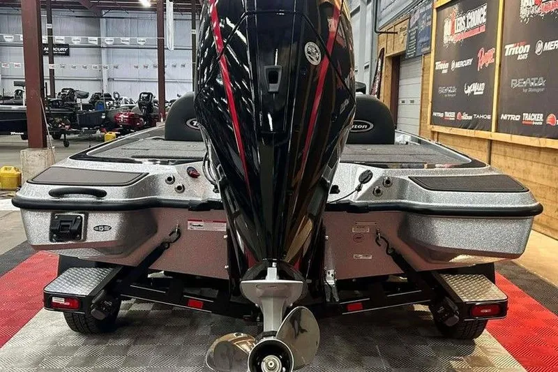 Slide: The Image of 2026 Triton 21XP Patriot boat in showroom, rear view with motor and propeller. - 5