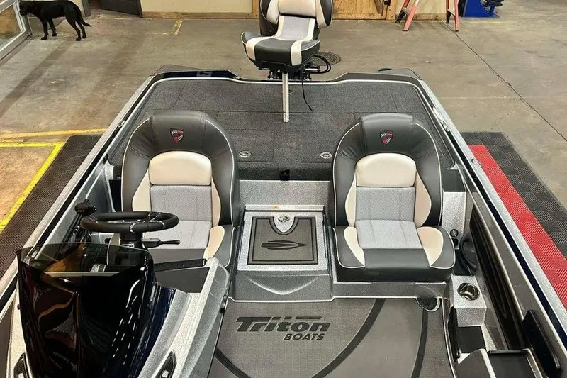 Slide: The Image of 2026 Triton 21XP Patriot boat interior with three seats and steering wheel in a showroom. - 6