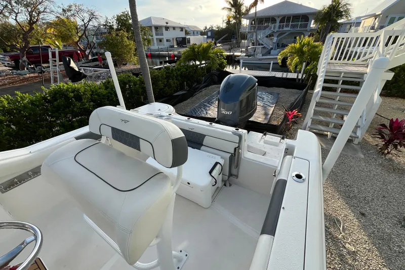 Slide: The Image of 2017 Tidewater 230 CC Adventure boat with seating and outboard motor in a marina setting. - 12