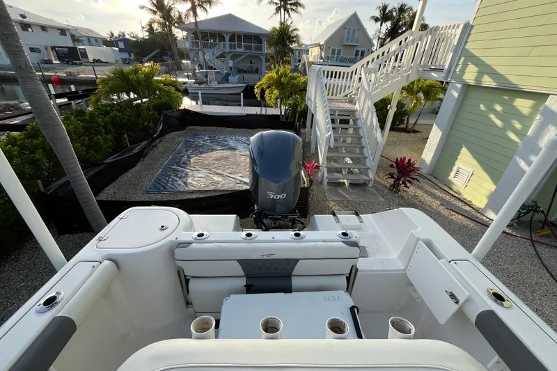 Slide: The Image of 2017 Tidewater 230 CC Adventure boat docked near waterfront homes and palm trees. - 13
