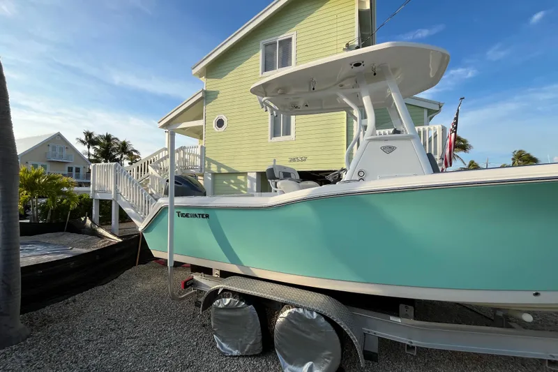Slide: The Image of 2017 Tidewater 230 CC Adventure boat on trailer beside a light green house. - 5