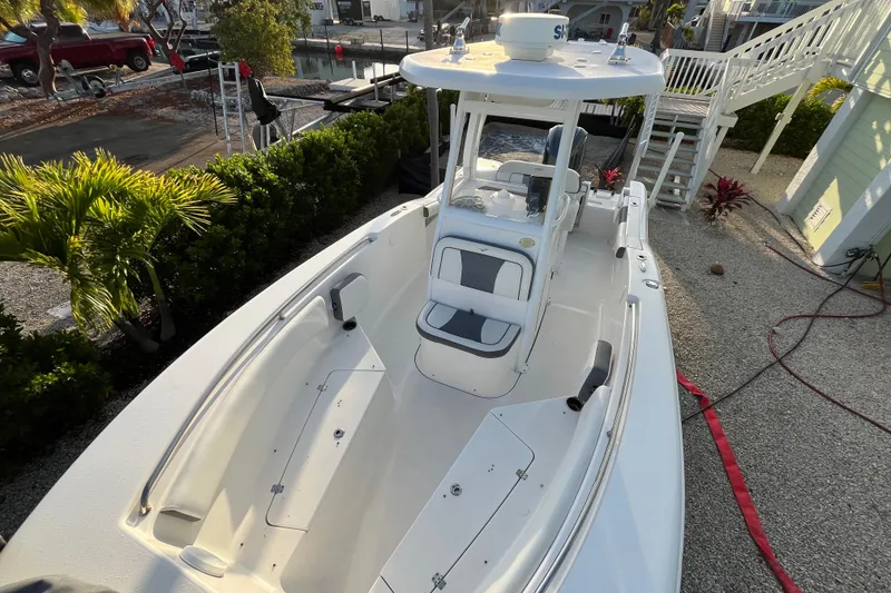 Slide: The Image of 2017 Tidewater 230 CC Adventure boat docked, featuring spacious seating and sleek design. - 8
