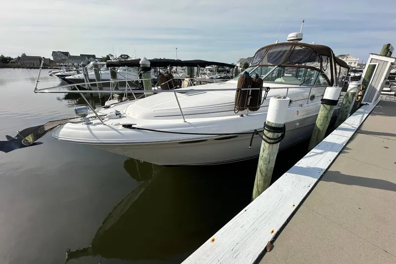 Slide: The Image of 2002 Sea Ray 340 Sundancer yacht docked at marina, calm water, clear sky. - 1