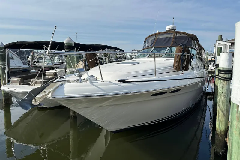 Slide: The Image of 2002 Sea Ray 340 Sundancer docked at marina, featuring sleek design and white exterior. - 2