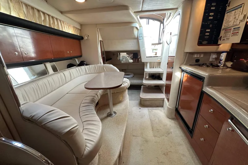 Slide: The Image of Interior of 2002 Sea Ray 340 Sundancer yacht with plush seating and kitchenette. - 24