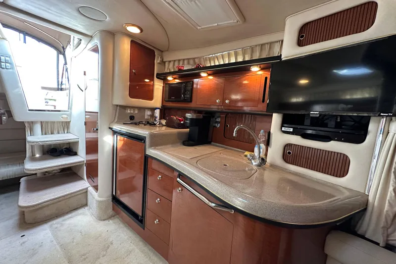 Slide: The Image of Luxurious interior of 2002 Sea Ray 340 Sundancer yacht with kitchenette and TV. - 25