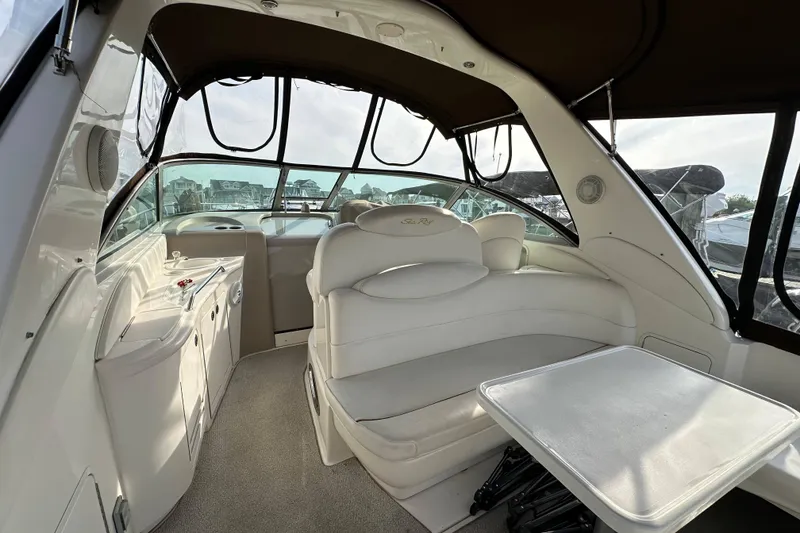 Slide: The Image of 2002 Sea Ray 340 Sundancer interior with white seating and table, showcasing luxury design. - 28