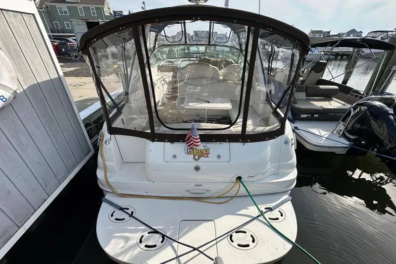 Slide: The Image of 2002 Sea Ray 340 Sundancer docked with clear canopy and American flag. - 3