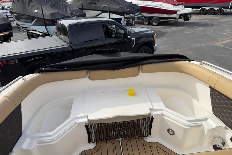 Slide: The Image of 2024 Sea Ray SDX 250 boat interior with tan seating and storage compartments. - 9