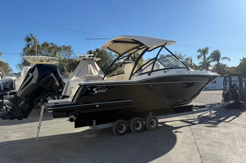 Slide: The Image of 2026 Scout 255 Dorado boat on trailer, parked outdoors under clear sky. - 0