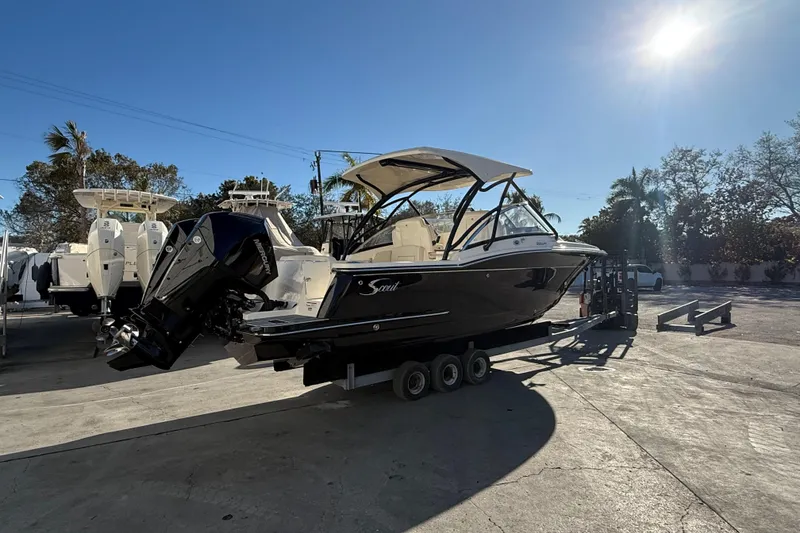 Slide: The Image of 2026 Scout 255 Dorado boat on trailer under clear blue sky. - 1