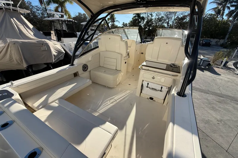 Slide: The Image of 2026 Scout 255 Dorado boat interior with seating and storage, parked outdoors. - 10