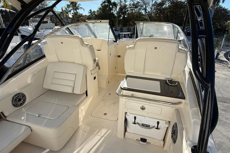 Slide: The Image of 2026 Scout 255 Dorado boat interior with seating and kitchenette, featuring a Yeti cooler. - 12
