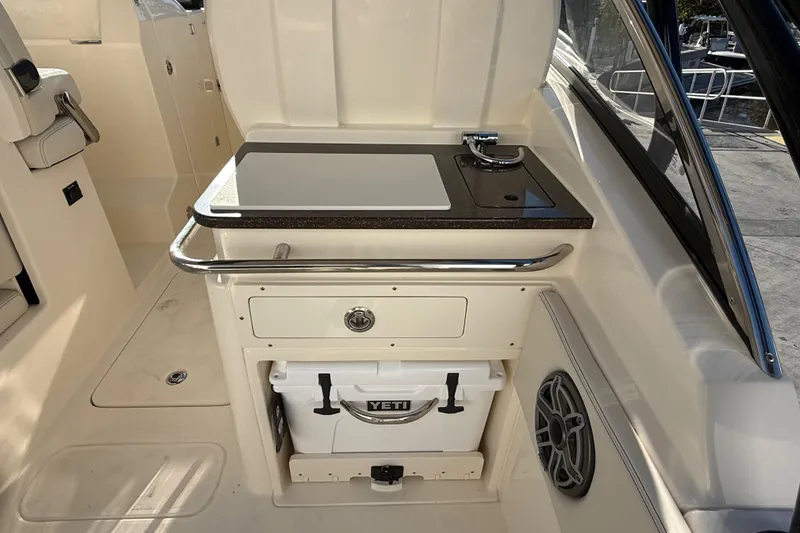 Slide: The Image of 2026 Scout 255 Dorado boat interior with sink, countertop, and Yeti cooler storage. - 13