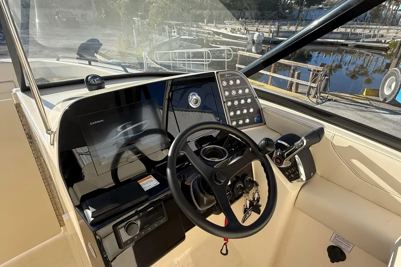Slide: The Image of 2026 Scout 255 Dorado boat cockpit with steering wheel and control panel. - 15