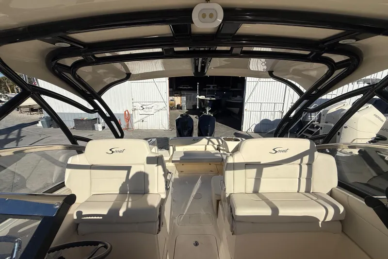Slide: The Image of 2026 Scout 255 Dorado boat interior with seating and helm, docked in a marina. - 22