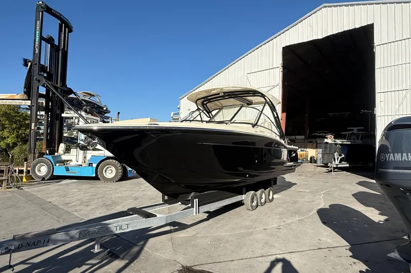 Slide: The Image of 2026 Scout 255 Dorado boat on trailer outside a large warehouse. - 5