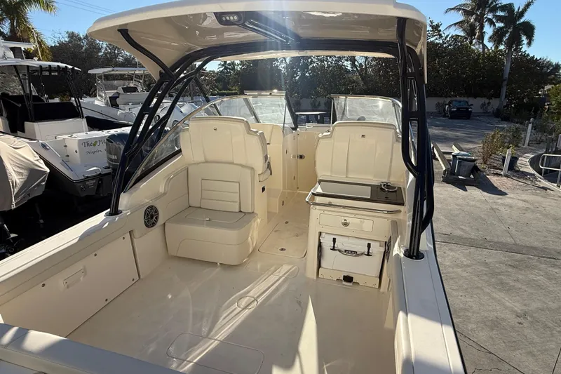 Slide: The Image of 2026 Scout 255 Dorado boat interior with seating and storage, docked under sunny skies. - 7