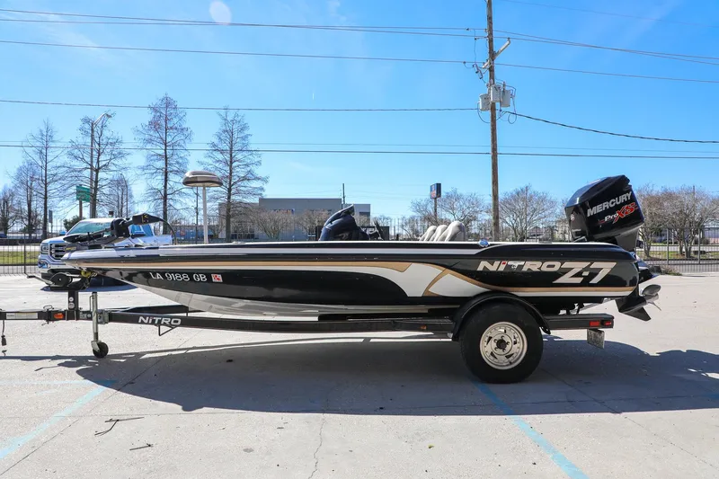 Slide: The Image of 2013 Nitro Z-7 boat on trailer, parked outdoors under clear blue sky. - 15