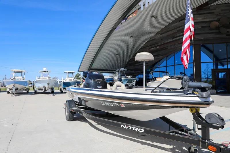 Slide: The Image of 2013 Nitro Z-7 boat on trailer outside dealership, American flag displayed. - 9