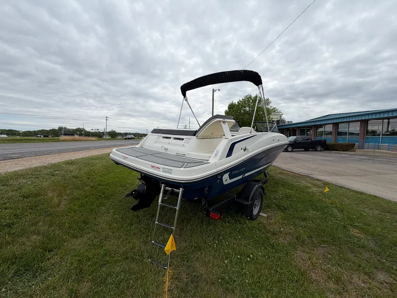 Slide: The Image of 2019 Bayliner V45 boat parked on grass under cloudy sky. - 3