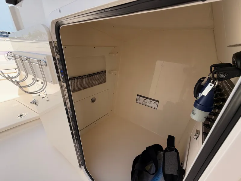 Slide: The Image of A spacious storage compartment on a Scout 288 Dorado boat, featuring rod holders and a flashlight. - 33