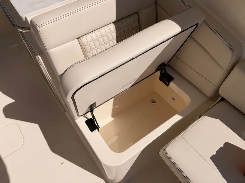 Slide: The Image of An open storage compartment on a 2027 Scout 288 Dorado boat, featuring beige upholstery. - 19