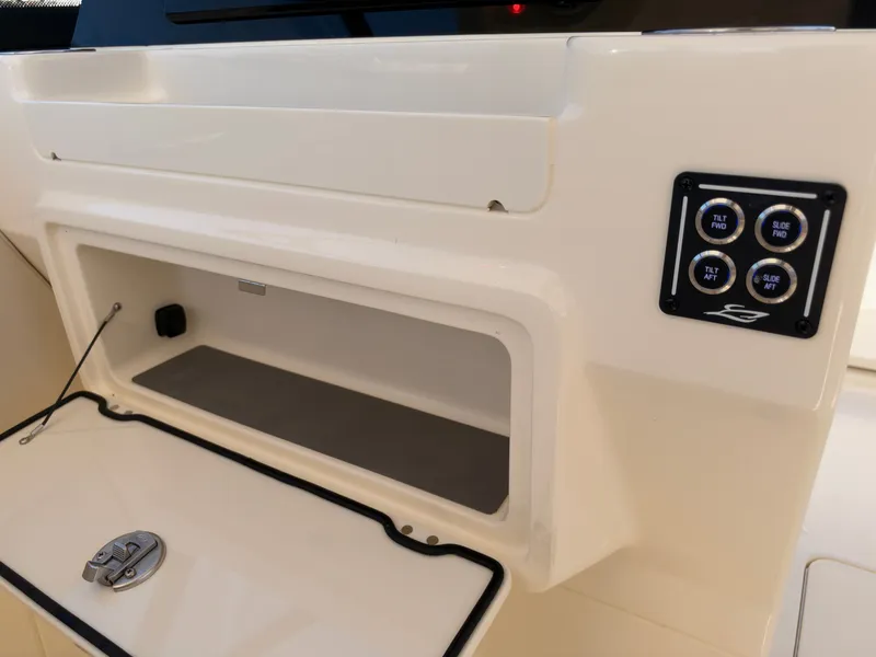 Slide: The Image of An open storage compartment on a Scout 288 Dorado boat, with control buttons beside it. - 36