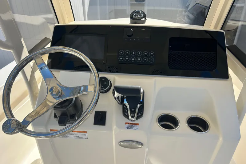 Slide: The Image of 2026 Scout 220 XSF boat dashboard with steering wheel and control panel. - 12