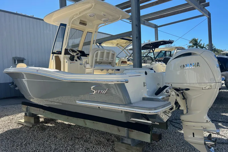 Slide: The Image of 2026 Scout 220 XSF boat with Yamaha engine, displayed outdoors on a stand. - 2