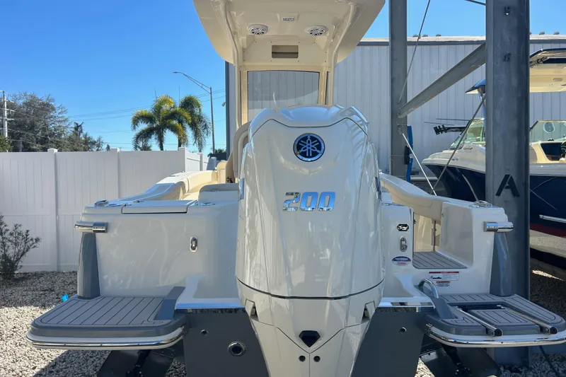 Slide: The Image of 2026 Scout 220 XSF boat with Yamaha 200 engine, docked outdoors. - 4