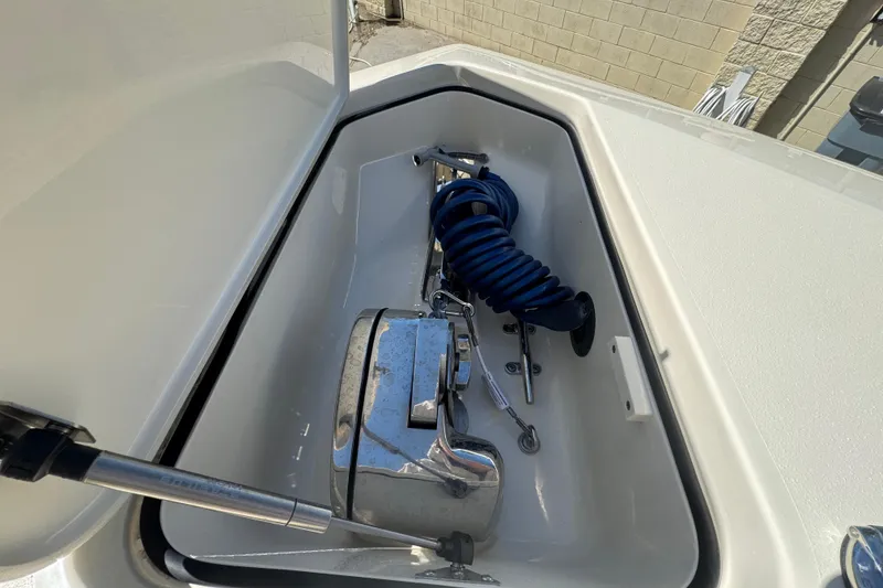 Slide: The Image of Storage compartment of 2025 Scout 260 LXF boat with coiled blue hose and anchor. - 10