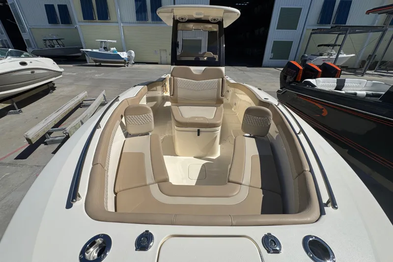 Slide: The Image of 2025 Scout 260 LXF boat interior with beige seating, docked at a marina. - 11