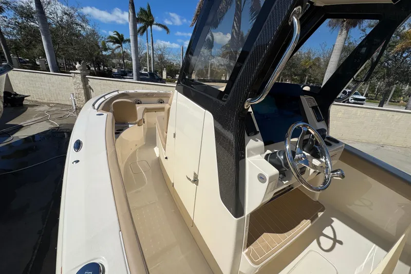 Slide: The Image of 2025 Scout 260 LXF boat interior with steering wheel and seating, under sunny skies. - 14