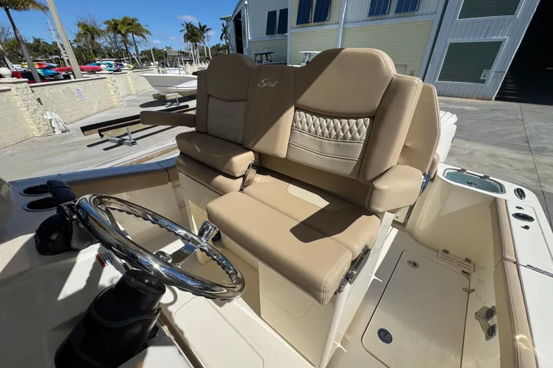 Slide: The Image of 2025 Scout 260 LXF boat interior with beige seating and steering wheel. - 20