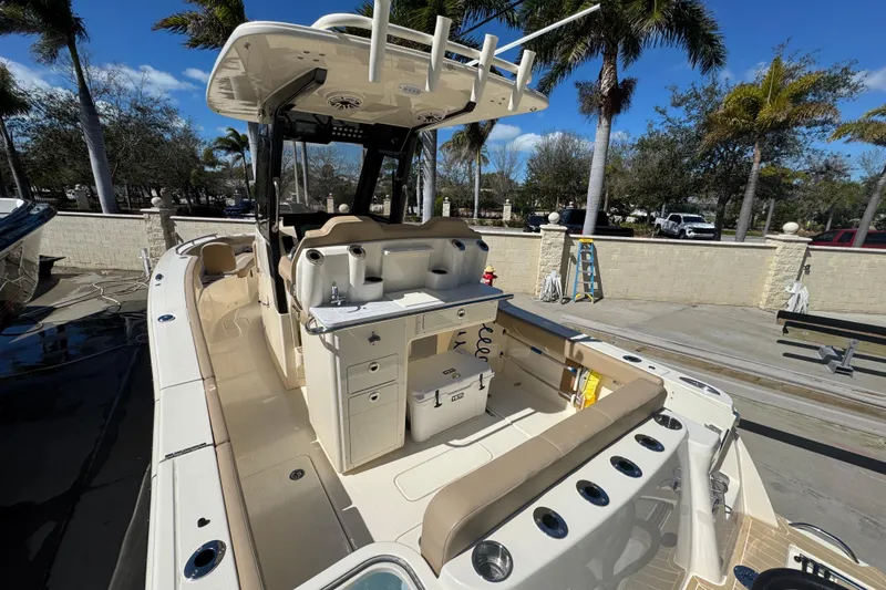 Slide: The Image of 2025 Scout 260 LXF boat with sleek design and spacious deck, parked outdoors. - 23