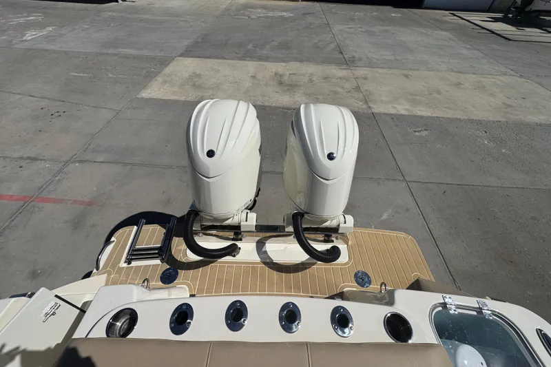 Slide: The Image of 2025 Scout 260 LXF boat with dual outboard engines on a dock. - 29