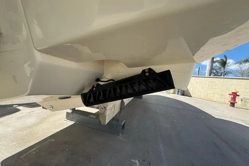 Slide: The Image of 2025 Scout 260 LXF boat hull detail with trim tab, outdoor setting. - 35
