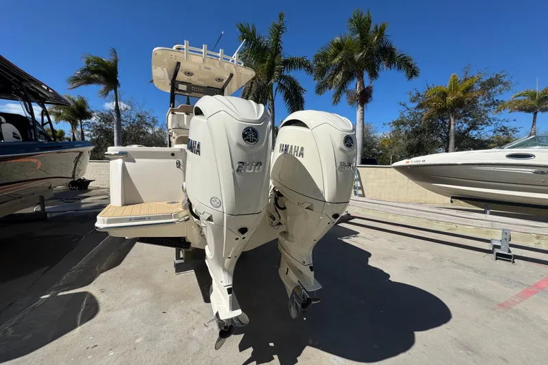 Slide: The Image of 2025 Scout 260 LXF boat with dual Yamaha engines, docked under palm trees. - 4