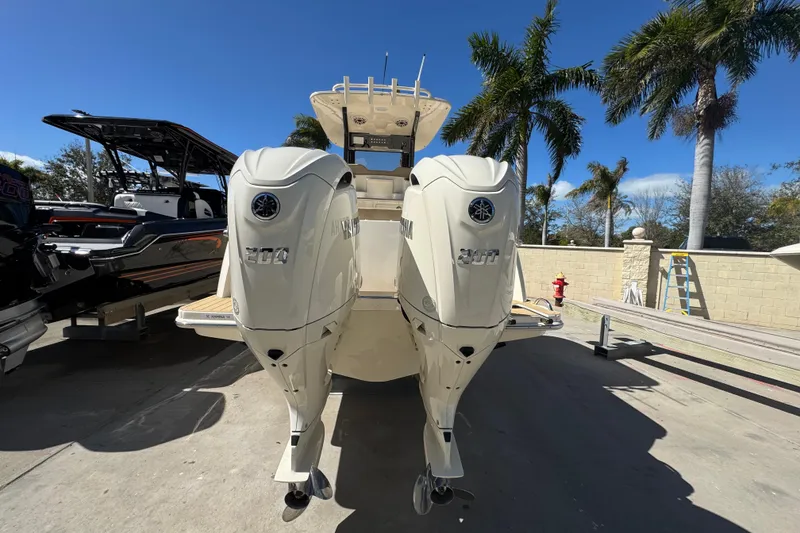 Slide: The Image of 2025 Scout 260 LXF boat with dual Yamaha engines, parked under clear blue sky. - 5