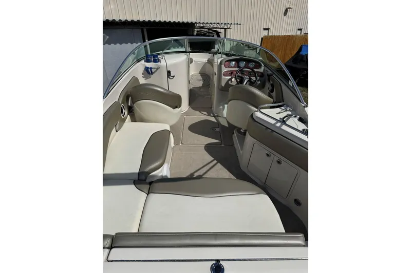Slide: The Image of 2006 Sea Ray 240 Sundeck interior with seating and helm, showcasing spacious design. - 12