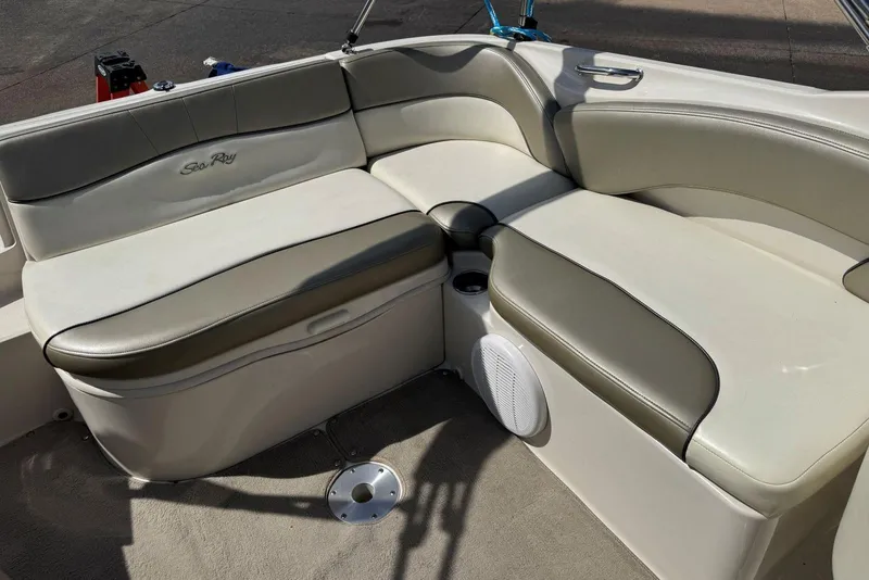 Slide: The Image of 2006 Sea Ray 240 Sundeck interior seating with beige upholstery and integrated speaker. - 15
