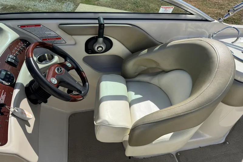 Slide: The Image of 2006 Sea Ray 240 Sundeck helm with steering wheel and comfortable captain's chair. - 19