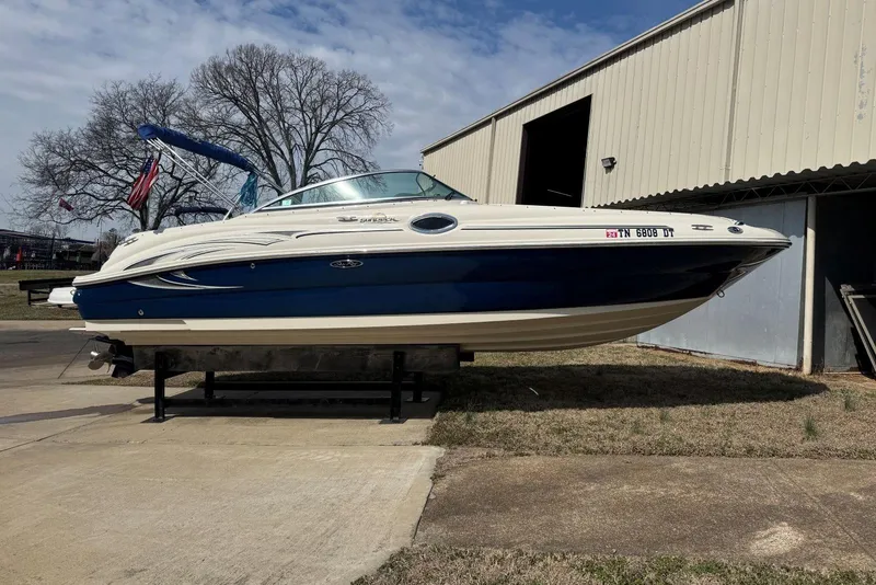 Slide: The Image of 2006 Sea Ray 240 Sundeck boat on display outside a storage building. - 2