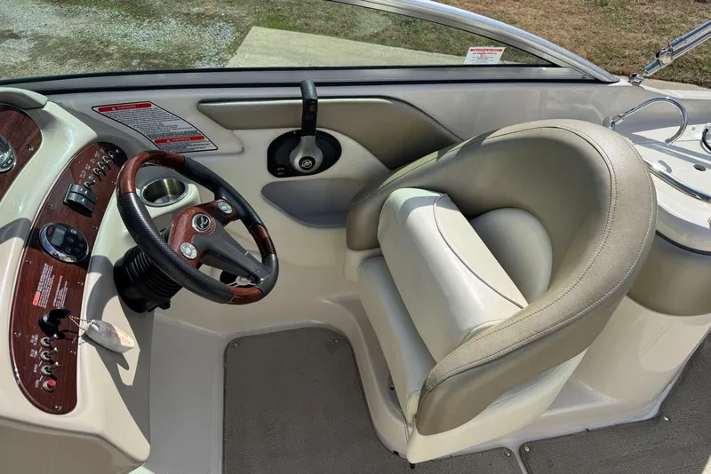 Slide: The Image of 2006 Sea Ray 240 Sundeck helm with steering wheel and comfortable captain's chair. - 20