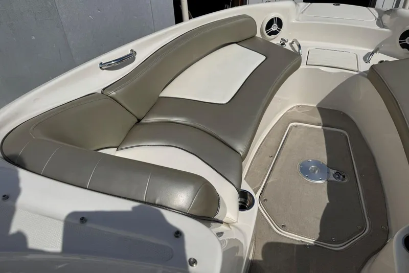 Slide: The Image of 2006 Sea Ray 240 Sundeck interior with cushioned seating and carpeted floor. - 25