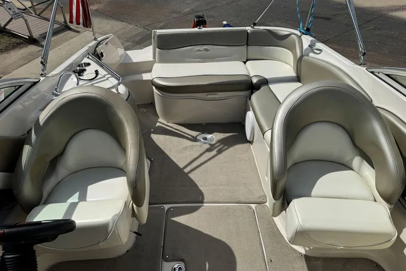 Slide: The Image of 2006 Sea Ray 240 Sundeck interior with plush seating and steering console. - 29
